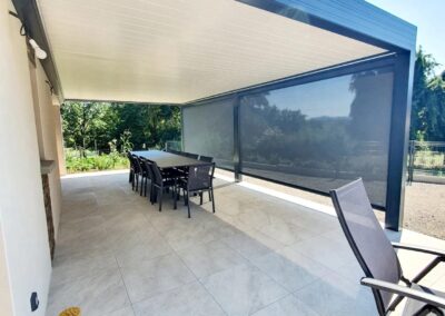 Vue de la pergola, la terrasse avec dessous une table et des chaises